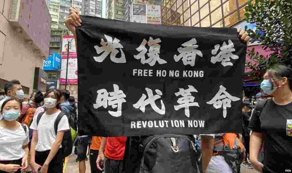 參與5-24港島反惡法遊行的人士高舉反送中運動的”光復香港、時代革命”標語，高舉這面標語旗幟在港版中國國家安全法實施後，可能會觸犯相關法例。(美國之音湯惠芸拍攝)