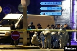 Investigators work on the street during a police operation during which the suspected gunman, Cherif Chekatt, who killed three people at a Christmas market in Strasbourg, was killed, in the Meinau district in Strasbourg, France, Dec. 13, 2018.