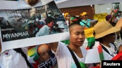 少数民族克钦人举着显示缅北克钦难民的图片在缅甸驻泰国使馆前抗议(2013年1月11日)