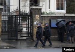 Police officers walk past the Russian embassy in London, Britain, March 12, 2018.
