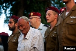 Israeli soldiers and a relative of Israeli soldier Bnaya Rubel mourn during Rubel's funeral in Holon, near Tel Aviv, July 20, 2014.