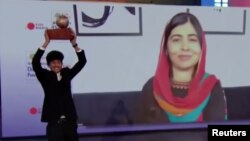 Sadat Rahman holds up his trophy prize as Malala Yousafzai cheers over video, during a ceremony on November 13 at The Hague.(Screenshot from Reuters video)