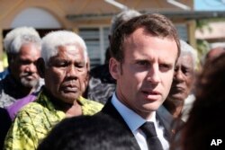 FILE - French President Emmanuel Macron is welcomed at Ouvea Island airport, off New Caledonia, May 5, 2018.