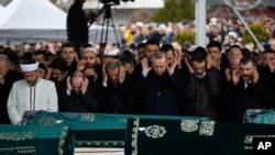 Turkey's President Recep Tayyip Erdogan, center, joins hundreds of mourners who attend the funeral prayers for nine members of Alemdar family killed in a collapsed apartment building, in Istanbul, Saturday, Feb. 9, 2019. 