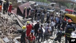 Regu pemadam kebakaran dan tim SAR mencari korban di sekitar lokasi meledaknya bom di Bab al-Muadham, Baghdad, Irak (4/6).