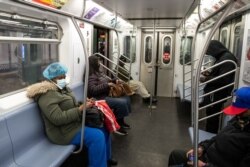 Warga di dalam kereta (subway) mengenakan masker di stasiun kereta api Times Square di tengah pandemi Covid-19 di New York City, 17 April 2020. (Foto: dok).