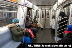 Warga di dalam kereta (subway) mengenakan masker di stasiun kereta api Times Square di tengah pandemi Covid-19 di New York City, 17 April 2020. (Foto: dok).