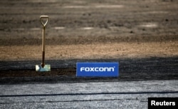 FILE - A shovel and Foxconn logo are seen before the arrival of U.S. President Donald Trump as he participates in the Foxconn Technology Group groundbreaking ceremony for its LCD manufacturing campus, in Mount Pleasant, Wis., June 28, 2018.