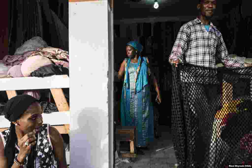 &quot;Fashion is everywhere in Dakar,&quot; says Dakar Fashion Week founder and designer Adama Paris, June 29, 2017. As if to prove her point, the stage of DFW&#39;s &quot;Street Show&quot; is surrounded on all sides by residents making their living off of clothes -- a shoe seller, a tailor, and pictured here Nichole Coly&#39;s fabric store.