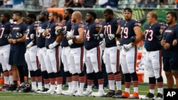 The Chicago Bears lock arms during the National Anthem in the first half of an NFL preseason football game against the Cincinnati Bengals, Aug. 9, 2018, in Cincinnati. 