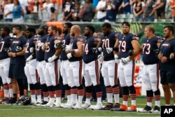 The Chicago Bears lock arms during the National Anthem in the first half of an NFL preseason football game against the Cincinnati Bengals, Aug. 9, 2018, in Cincinnati.
