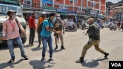 FILE - Policemen attack a photojournalist who was covering the Muharram procession in Srinagar on Aug. 17, 2021. (VOA/Faisal Bashir)