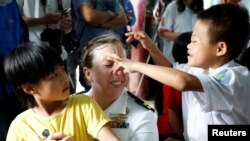 Nữ thủy thủ Mỹ chơi đùa với các trẻ em nhiễm chất da cam.