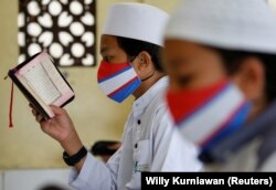 Siswa Muslim mengenakan masker wajah di tengah penyebaran COVID-19, saat membaca Alquran di Masjid Al-Kautsar Daarul Qur'an selama bulan suci Ramadhan, di Bogor, Jawa Barat, 9 Mei 2020 . (Foto: Reuters/Willy Kurniawan)