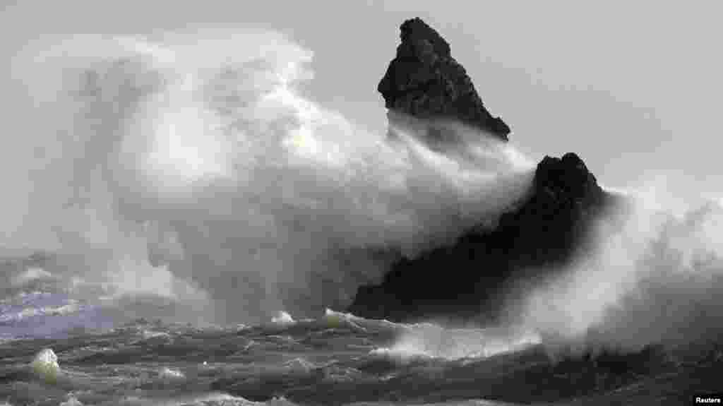 Waves crash over Church Rock in strong winds at Broad Haven, in Wales. More flood warnings were issued for England, Wales and Scotland as strong winds and heavy rain returned to Britain.