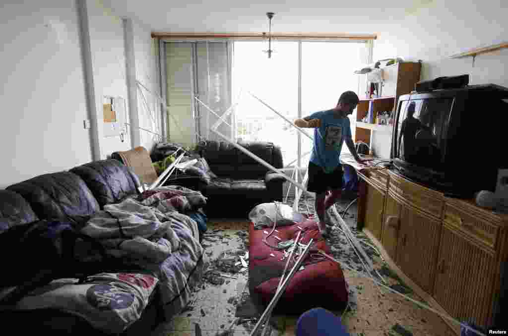 An Israeli surveys the damage to his apartment after a rocket struck a nearby house in the southern coastal city of Ashkelon, Aug. 26, 2014.