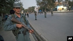 An Afghan policeman guards the area near the house of the head of Afghanistan's High Peace Council Burhanuddin Rabbani after a suicide bombing killed the former Afghan president Tuesday, Kabul, September 20, 2011.