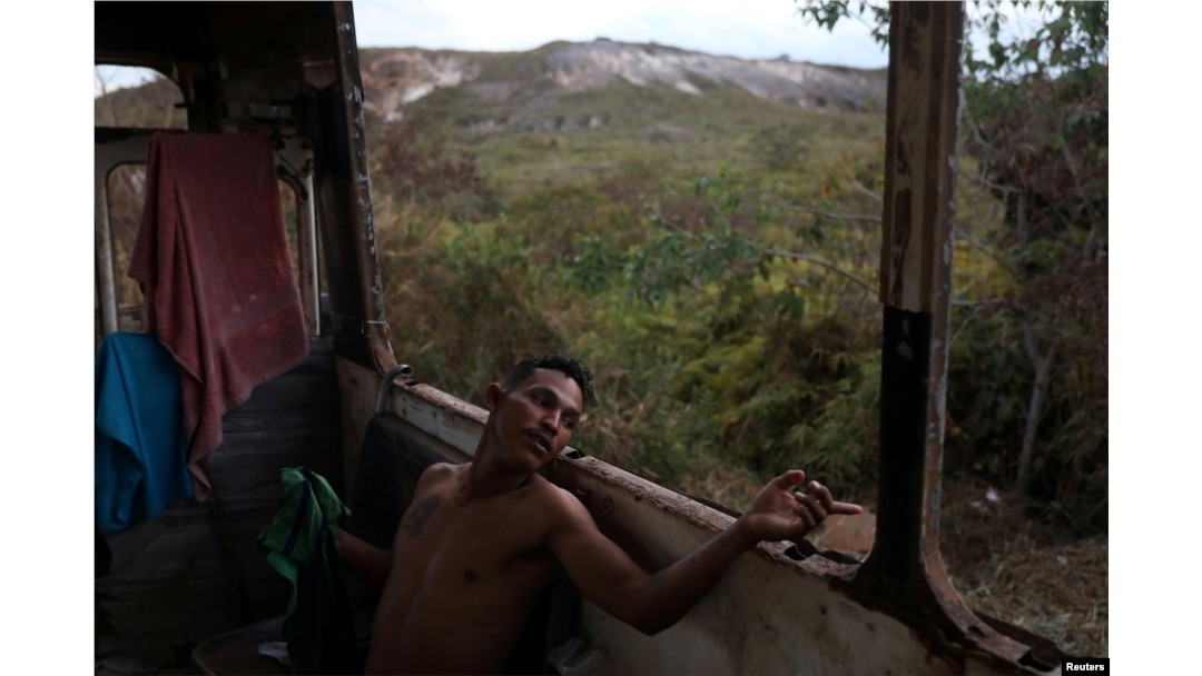 Venezuelan Hildemaro Ortiz relaxes inside of an abandoned bus in the border city of Pacaraima, Brazil, April 13, 2019.