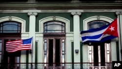 FILE - A Jan. 19, 2015, photo shows the Cuban and U.S. flags waving from the balcony of the Hotel Saratoga in Havana.