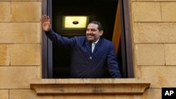 Lebanese Prime Minister Saad Hariri waves to his supporters from a window of his residence, in Beirut, Lebanon, Nov. 22, 2017. 
