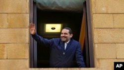 Lebanese Prime Minister Saad Hariri waves to his supporters from a window of his residence, in Beirut, Lebanon, Nov. 22, 2017. 