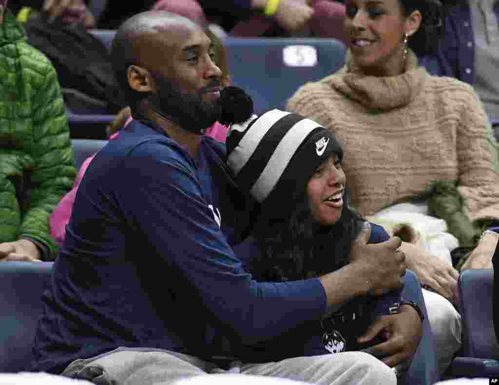 Kobe Bryant e a sua filha Gianna assistem o jogo de basquetebol universitário entre as equipas de Connecticut e Houston a 2 Março 2019, em Storrs, Connecticut . (AP Photo/Jessica Hill)