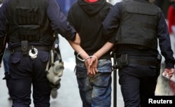 FILE - Turkish riot police officers detain a May Day protester in central Istanbul. Human rights advocates say their ability to stem the current deteriorating human rights is being weakened because they are being blocked by the post-coup crackdown.