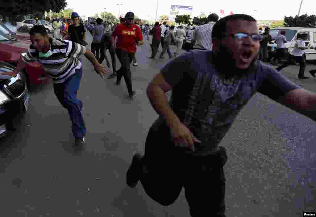 Supports of former Egyptian President Mohamed Morsi run during demonstrations outside the Republican Guard building in Cairo July 5, 2013.&nbsp;