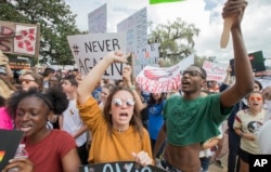 Therese Gachnauer, center, a 18 year old senior from Chiles High School and Kwane Gatlin, right, a 19 year old senior from Lincoln High School, both in Tallahassee, join fellow students protesting gun violence on the steps of the old Florida Capitol.