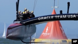 Oracle Team USA crosses the finish line during the 18th race of the America's Cup sailing event against Emirates Team New Zealand, Sept. 24, 2013, in San Francisco. 