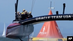Oracle Team USA crosses the finish line during the 18th race of the America's Cup sailing event against Emirates Team New Zealand, Sept. 24, 2013, in San Francisco. 