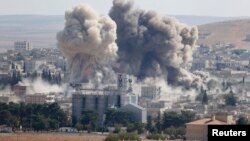 Un nuage de fumée s’élève après les frappes de la coalition internationale menée par les Etats-Unis contre une position de l'armée syrienne à Kobane, Syrie, 8 octobre 2014.