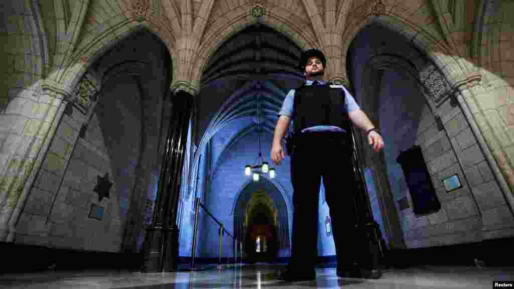 A security guard patrols the hallway near the entrance to the Parliamentary Library on Parliament Hill in Ottawa, Oct. 23, 2014.