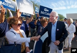 FILE - Republican Senator John McCain and his wife, Cindy, greet supporters after casting their ballots at a polling station, in Phoenix, Arizona, Nov. 8, 2016.