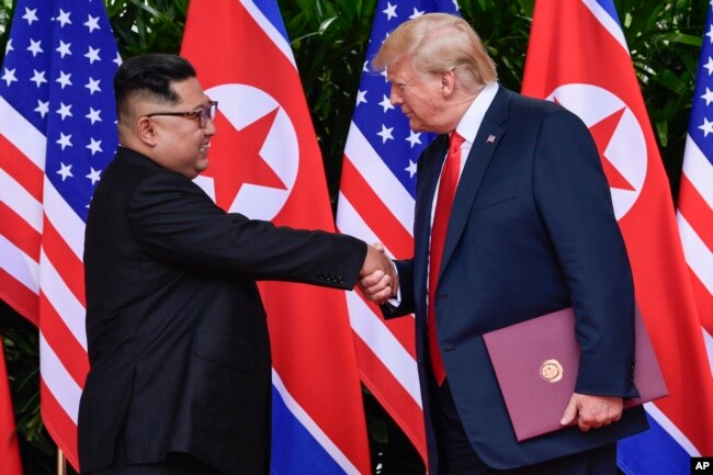 FILE - In this June 12, 2018, file photo, North Korea leader Kim Jong Un, left, and U.S. President Donald Trump shake hands at the conclusion of their meetings at the Capella resort on Sentosa Island in Singapore.