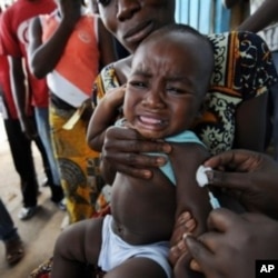 A health worker administers a yellow fever vaccine to a baby on a roadside in Abidjan, Ivory Coast after a case was discovered of yellow fever (File)