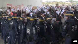 In this grab taken from video, police control protesters, during a demonstration near the migrant camp, in Calais, France, Oct. 1, 2016. 