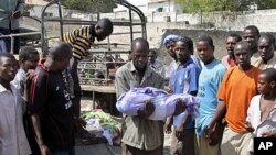 A Somali man carries the body of a one year old child who was killed by a mortar shell that slammed into a family's house Sunday night, to a grave in the capital Mogadishu, Somalia, March 19, 2012. 