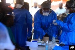 Healthcare workers from the World Health Organization prepare to give an Ebola vaccination to a front line aid worker in Beni Democratic Republic of Congo, Aug 10, 2018.