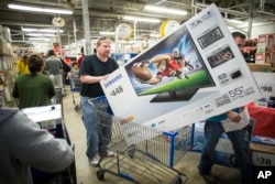 Patrick Bowhay leaves happy from a Wal-Mart store with a Samsung 55-inch television, Nov. 24, 2016.