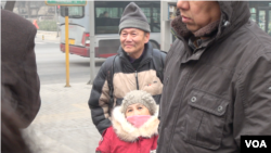 2015年12月22日上午，维权人士倪玉兰和丈夫董继勤来到法院外声援浦志强，有便衣试图遮挡记者拍照（美国之音叶兵拍摄）