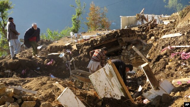 Pobladores paquistaníes de la aldea de Shangla, en el valle de Swat, recogen sus pertenencias de entre los escombros de sus casas destruidas por un terremoto, el lunes 26 de octubre de 2015.  