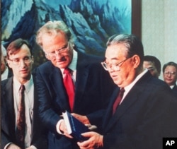 1992년 4월 평양을 방문한 빌리 그레이엄 목사(가운데)가 김일성 주석에게 자신의 저서와 성경을 선물했다.