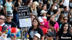 Demonstrators protest during a strike against Brazilian Social Welfare reform project, in Curitiba, Brazil March 15, 2017. The placard reads: "Work until die? No to reform." 