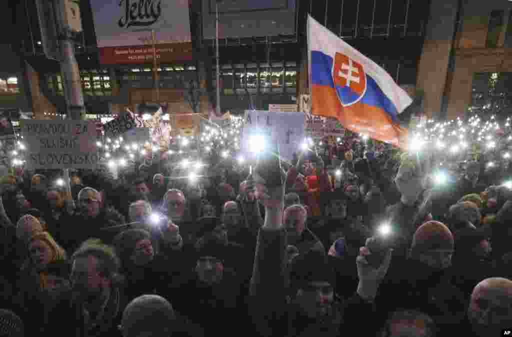 Demonstrators use their smartphones as torches during an anti-government rally in Bratislava, Slovakia, March 9, 2018. 