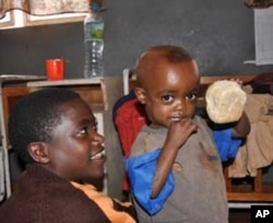 Kefyalew, 3, shows his lunch (right) Markos Ayele, 13, oldest of four orphans