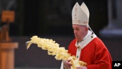 El Papa Francisco sostiene una rama de palma mientras celebra la Misa del Domingo de Ramos a puertas cerradas en la Basílica de San Pedro, en el Vaticano, el domingo 5 de abril de 2020, durante el encierro destinado a frenar la propagación de la infección COVID-19, causada por el nuevo coronavirus.