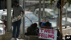 FILE: Workers advertise their skills looking for work outside a hardware store in a Johannesburg suburb, Wednesday, Feb. 26, 2020