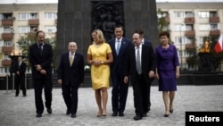 U.S. Republican Presidential candidate Mitt Romney and his wife Ann walk with dignitaries as they visit the monument to the Ghetto Heroes in Warsaw, July 31, 2012. 