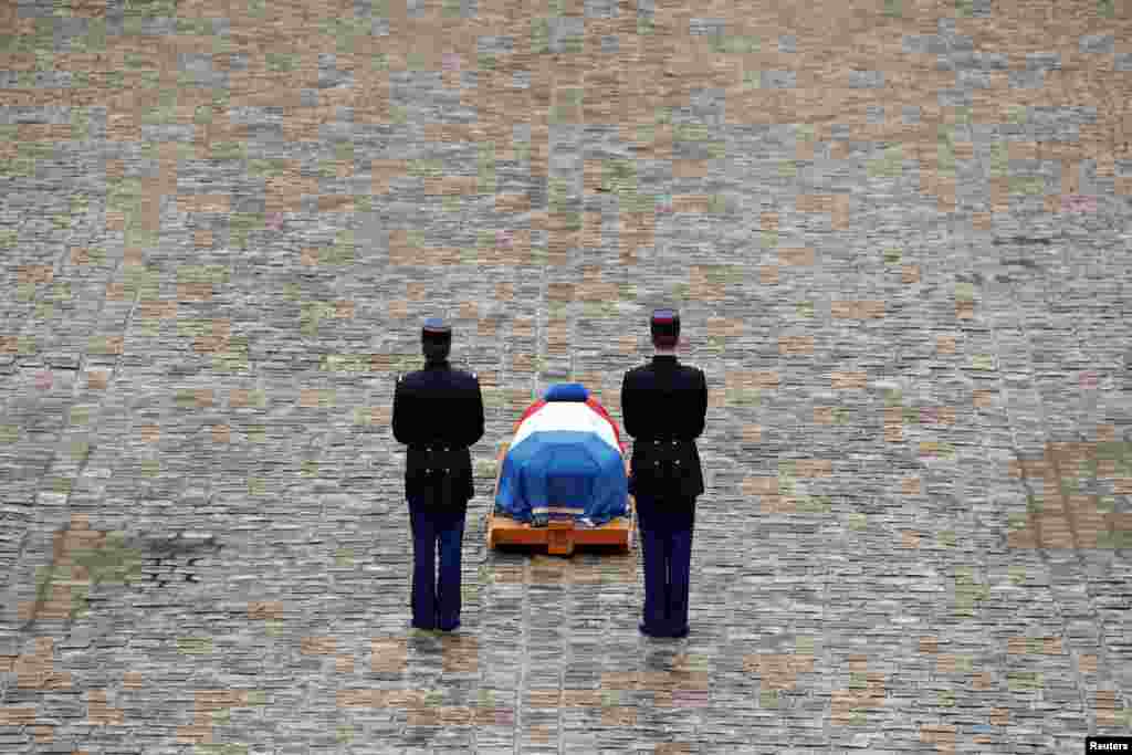 French Republican guards stand in front of the flag-draped coffin of late Gendarmerie officer Colonel Arnaud Beltrame, who was killed by an Islamist militant after taking the place of a female hostage during a supermarket siege in Trebes, during a national ceremony at the Hotel des Invalides in Paris,